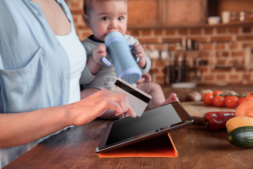 用数字平板电脑和信用卡在网上购买妇女及婴儿男图片