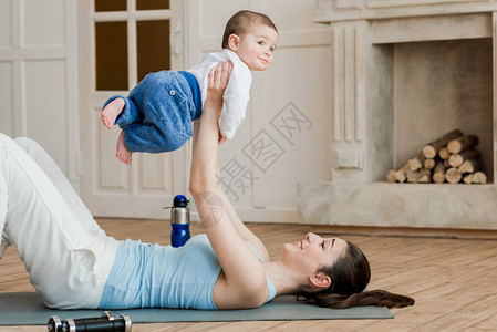在瑜伽垫子上躺着的和训练后玩耍的孩图片