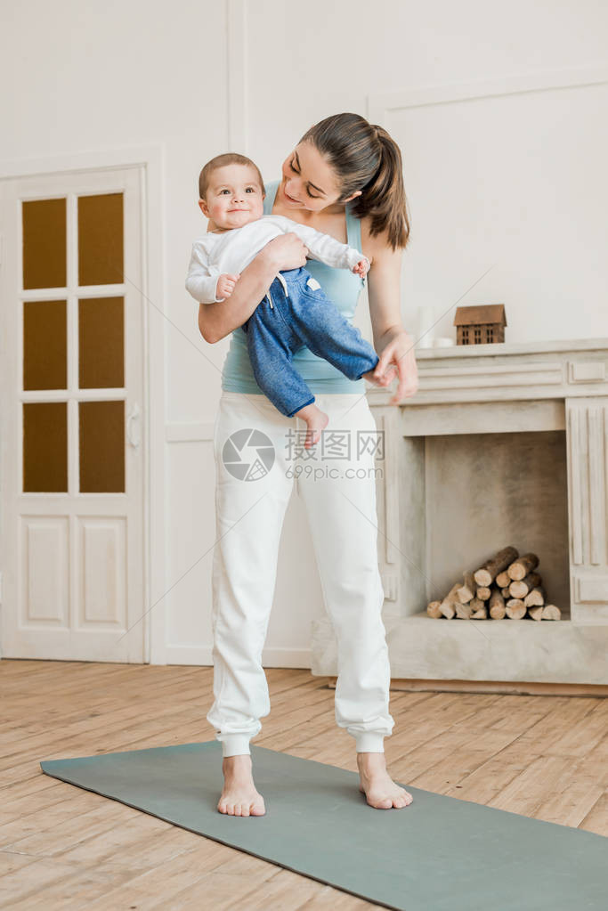母亲抱着婴儿男孩的怀抱准备在图片
