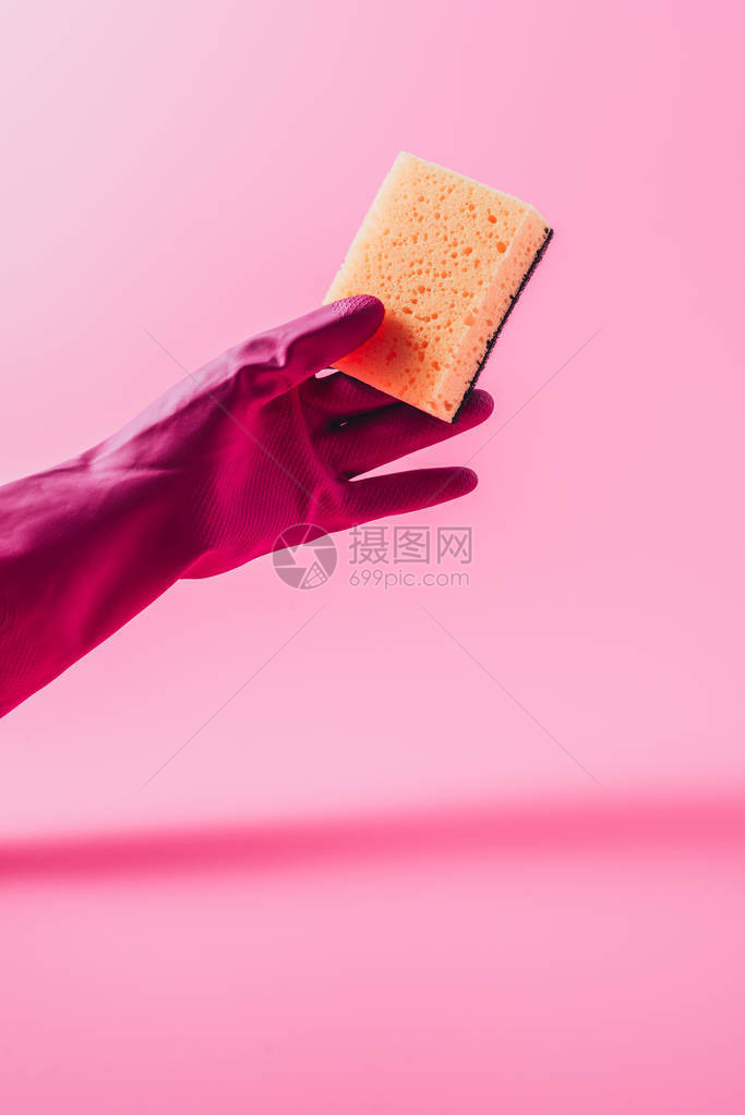 粉红色背景的橡胶手套中女清洁剂部分取景含冲洗海绵图片