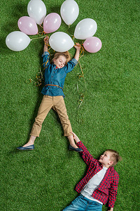 在草地上带着气球抱着微笑的女孩的图片