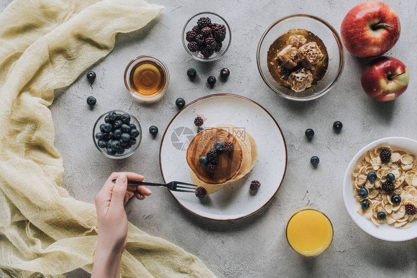 使用自制煎饼新鲜水果和灰色蜂蜜吃健康早餐图片