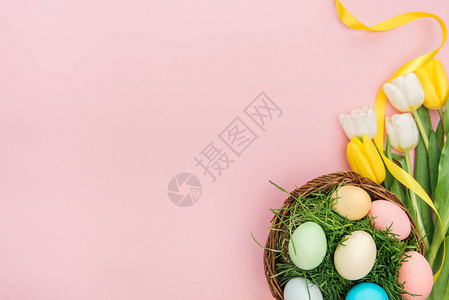 郁金香花和东方蛋的顶部视图在粉红色上隔图片