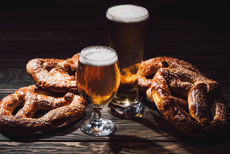 两杯啤酒和木桌上美味的面包图片