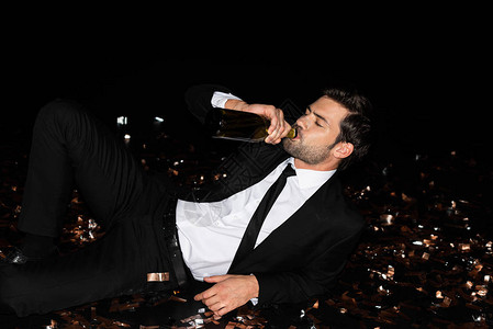 优雅的男子喝瓶酒香槟图片
