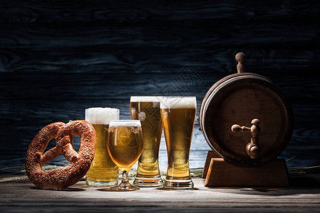 杯子啤酒脆饼和木桌啤酒桶图片