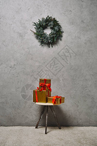 金色圣诞礼物盒在房间里的花圈下椅图片