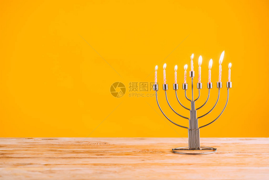 黄色的木桌上放着蜡烛的台光明节庆祝图片