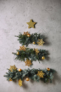 手工制作的圣诞树和星挂在房间的灰色墙上图片