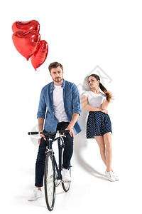 快乐的一对情侣骑自行车和红心气球图片