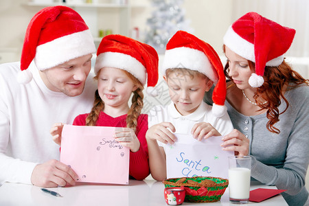 小孩的肖像和他们的父母拿着给圣诞老图片