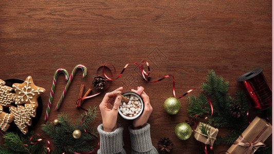 盛满热巧克力和棉花糖饼干糖果甘蔗和木本底圣诞节装饰品的杯子者图片