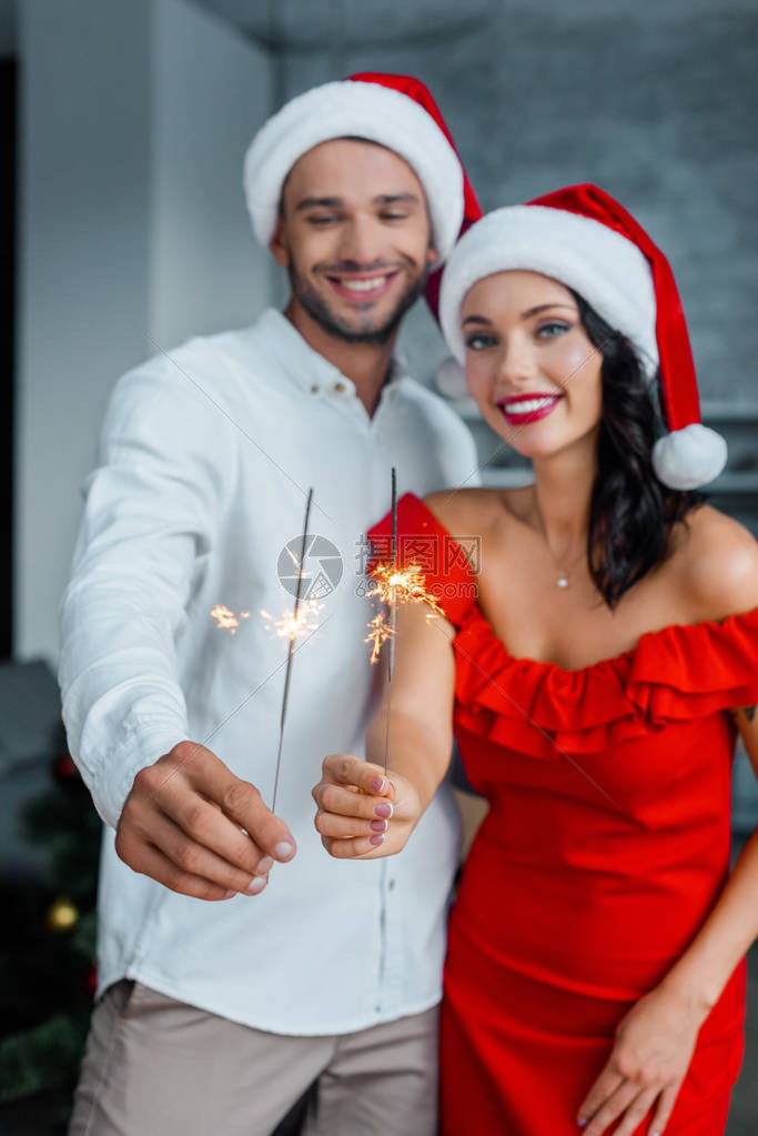 年轻夫妇在圣诞节帽子中有选择焦点在图片