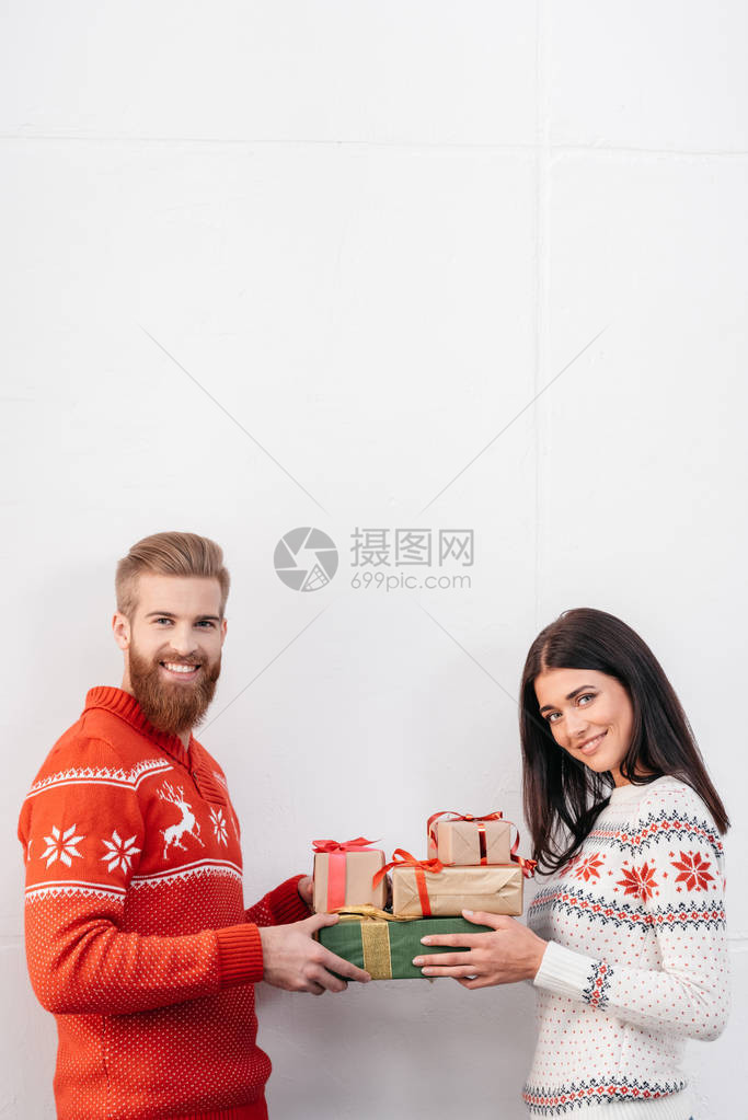 快乐的一对年轻夫妻拿着圣诞礼物图片