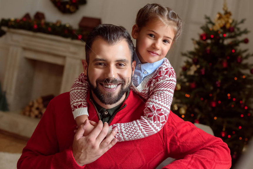 快乐的父亲和女儿拥抱并微笑着在圣诞图片