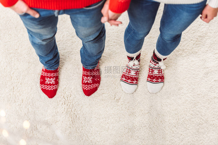 穿着编织袜子的年轻夫妇在家中站在一图片