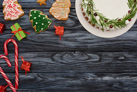 圣诞派糖果甘蔗小礼物和黑木桌上图片
