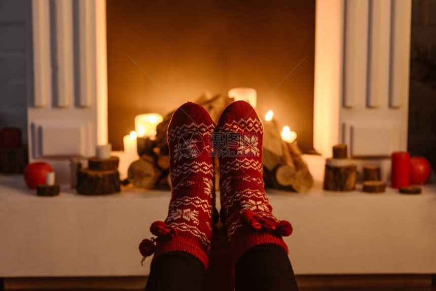 在节日冬季袜子和背景壁炉中妇女图片