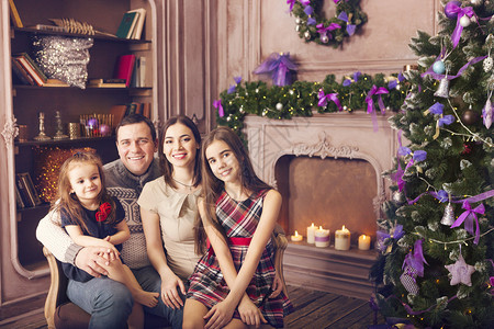 时尚的幸福家庭在圣诞节树上过的房图片