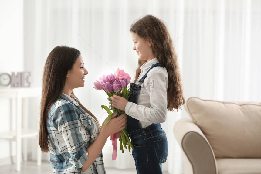 可爱的小女孩把郁金香花束送给她妈图片