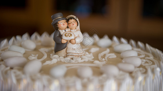 新娘和新郎在婚礼蛋糕礼帽上图片