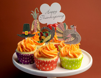 感恩节快乐用火鸡朝圣帽和玉米面装饰的蛋糕站在棕色背景下图片