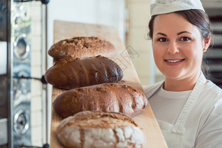 在面包店送面包的贝克女人看着图片