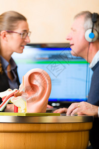 有听力问题的老年男子或养恤金领取者进行听力测试背景图片