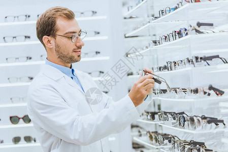 从眼科店架子上摘眼镜的男专业男职业ocu图片