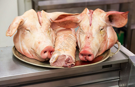 一对猪头在一家屠宰店的盘子上一图片