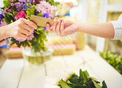 收信用卡在商店付款的女图片