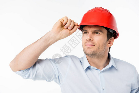 年轻男建筑师身戴硬帽子看着距图片