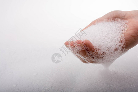 泡沫背景上的洗手和肥皂泡沫图片