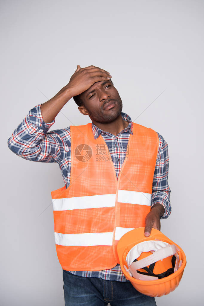 半长镜头的建筑工人背心和硬帽擦汗图片