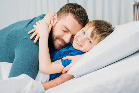 父亲拥抱着微笑的小孩躺在医院床上爸和图片