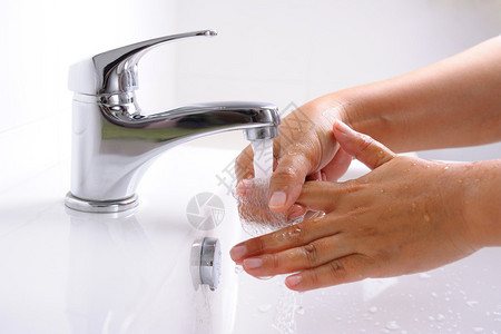 在浴室里用流动的自来水洗手背景图片