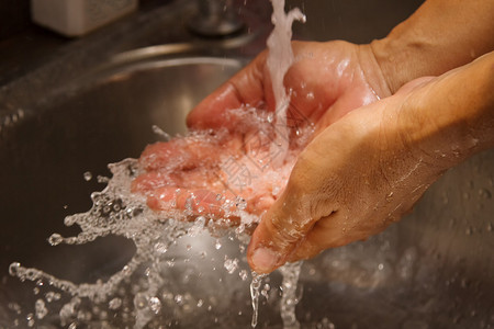 卫生职业工作者在纯净的自来水下洗手图片