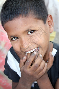一个害羞的可怜的印度孩子将脏手指塞图片