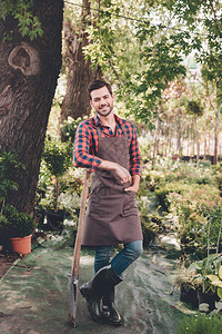 穿着围裙和橡皮靴的微笑着园丁的园丁图片