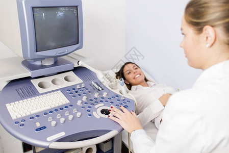 怀孕的年轻孕妇在科医生用超声波装置图片