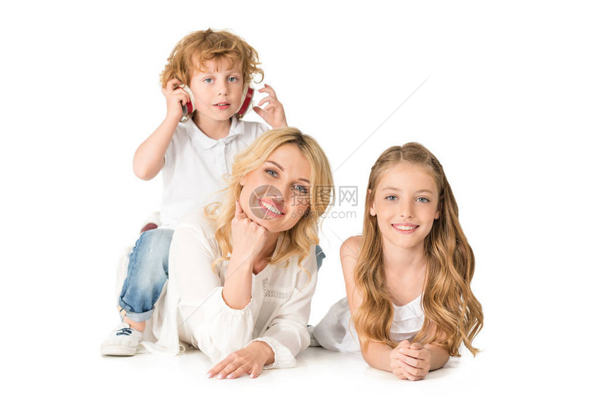 带着女儿和小儿子戴着耳机微笑的母亲看着被白图片