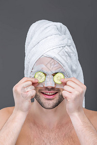男人用毛巾科拉根面罩和黄瓜切片在眼睛上图片
