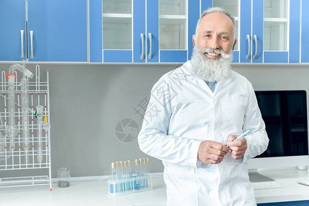 穿着白大衣在化学实验室内装有试剂的管子的快乐长胡图片