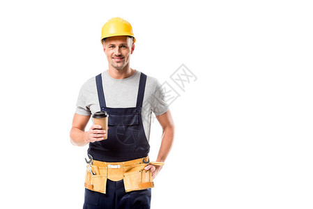 身戴头盔的笑着建筑工人喝咖啡在图片