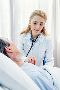 躺在床上的中年病人和在医院用听诊器图片