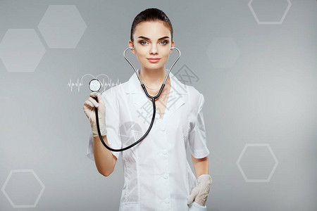穿着灰色背景的白色医疗长袍和听诊器保健和药理概念图片