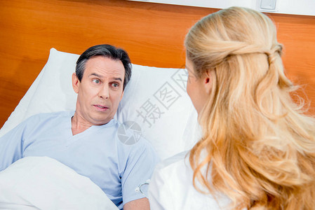 躺在床上的中年病人和在医院里坐在图片