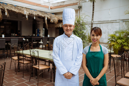微笑的亚洲厨师和女服务员图片