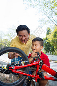 越南男子向儿子解释自行车机身制校对P图片