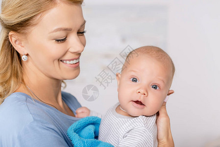 微笑的母亲将婴儿抱在图片